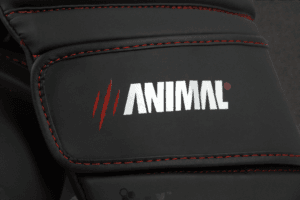 Close-up of the Animal Athletics logo on the wrist strap of the Predator Series red accent boxing gloves.