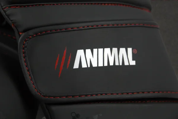 Close-up of the Animal Athletics logo on the wrist strap of the Predator Series red accent boxing gloves.
