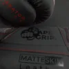 Close-up of ApeGrip V2 and MatteSkin branding on the Predator Series red accent boxing gloves.