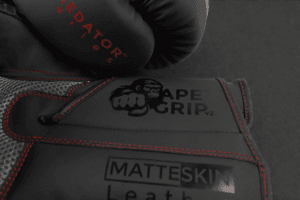 Close-up of ApeGrip V2 and MatteSkin branding on the Predator Series red accent boxing gloves.
