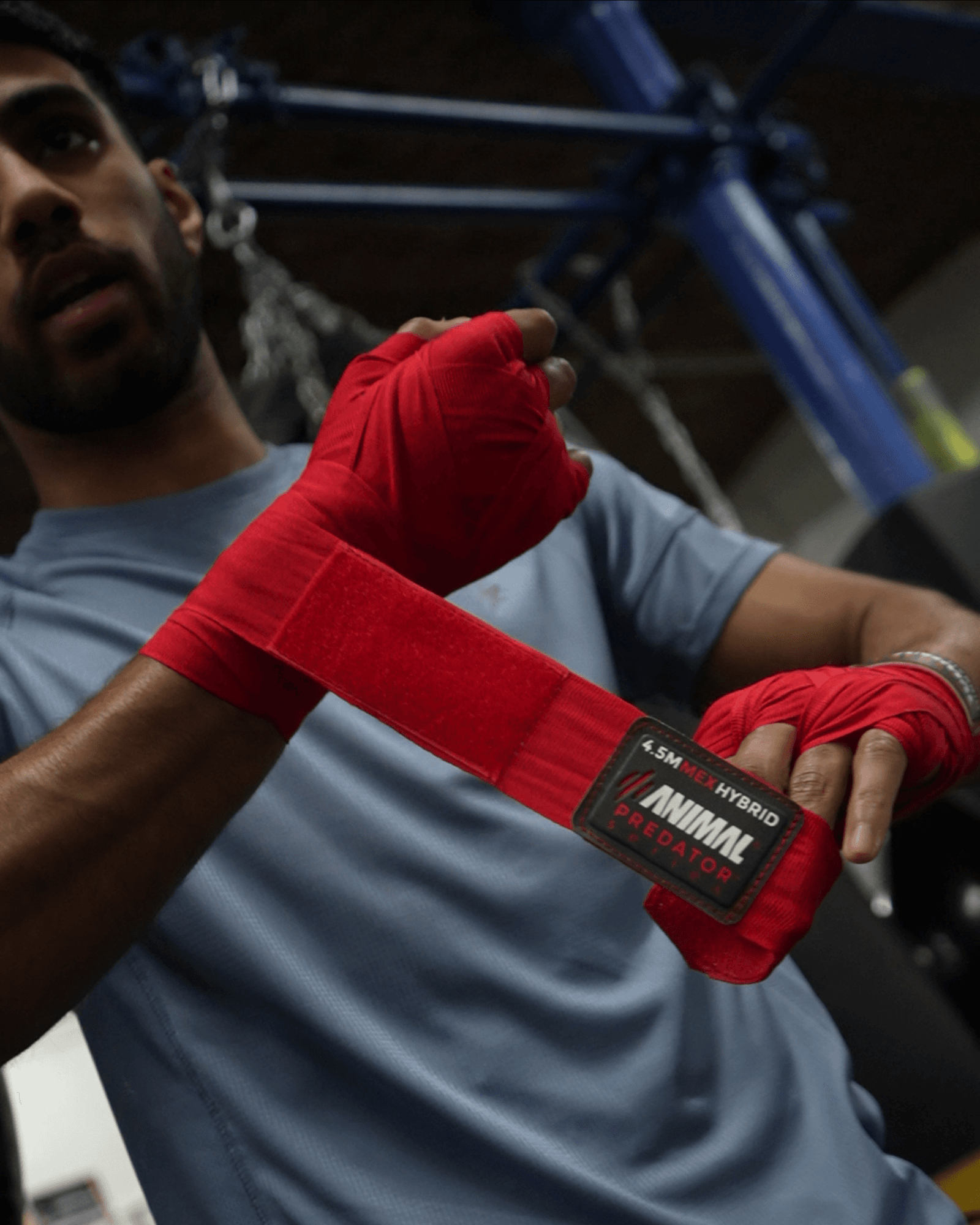 Boxer wrapping hands with red Mexican-style hand wraps before training.