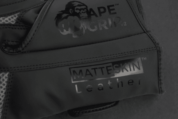 Close-up of ApeGrip V2 and MatteSkin leather branding on the Predator Series black accent boxing gloves.
