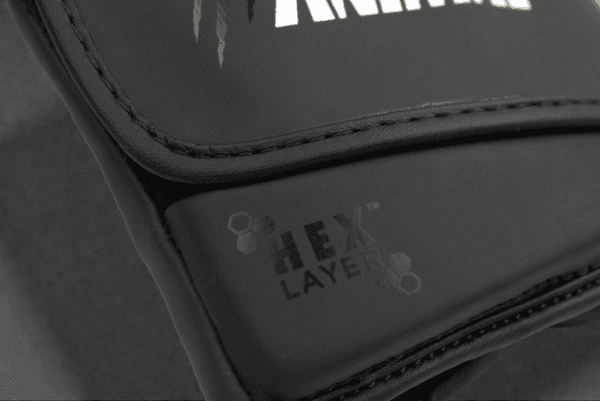Close-up of the HexLayer padding logo on the Predator Series black accent boxing gloves.
