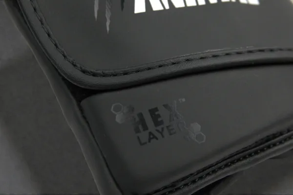 Close-up of the HexLayer padding logo on the Predator Series black accent boxing gloves.