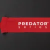 Predator Series red boxing hand wrap laid out long on a dark textured surface with thumb loop visible.