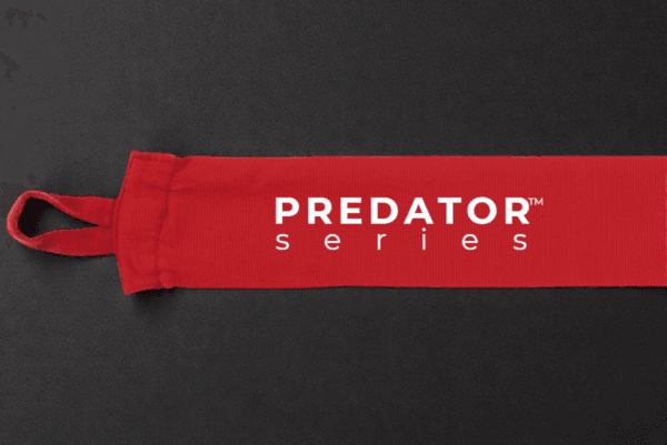 Predator Series red boxing hand wrap laid out long on a dark textured surface with thumb loop visible.