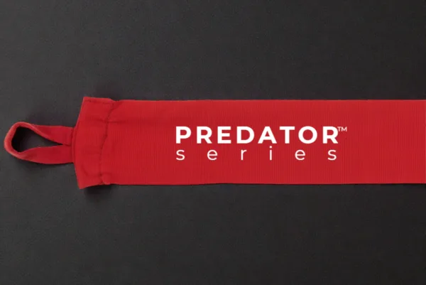 Predator Series red boxing hand wrap laid out long on a dark textured surface with thumb loop visible.