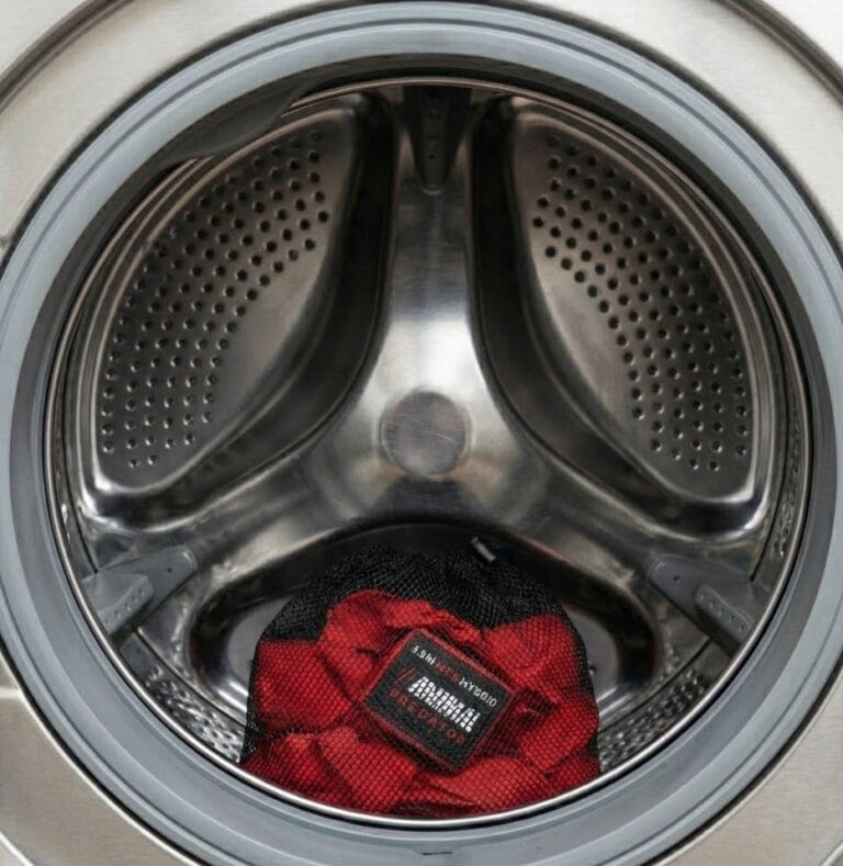 Boxing hand wraps placed inside a netted laundry bag in a washing machine drum to prevent tangling and fabric damage.